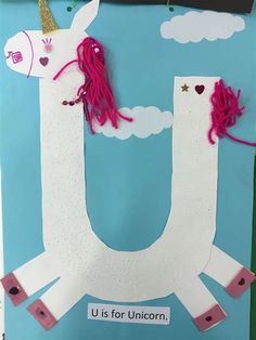 a paper cutout of a unicorn with pink manes on its back and the words u is for unicorn