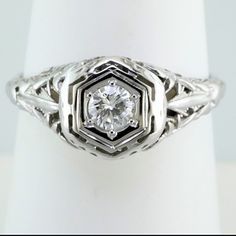 an antique style diamond ring with filigree accents