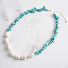 Step into the world of bohemian elegance with our Baroque Pearl Turquoise Necklace , a masterpiece that seamlessly blends the raw beauty of natural stones with the sophistication of pearls. This striking necklace is crafted from high-quality materials, featuring a dynamic combination of turquoise chips and lustrous pearls. The turquoise stones, with their rich blue-green hues and unique veining, offer a vibrant contrast to the smooth, iridescent pearls, each one distinct in its organic shape and glossy finish.   Let this necklace be the centerpiece of your jewelry collection, a symbol of your unique taste and sophisticated charm. DETAILS Plating: 14K Gold Materials: 925 Sterling Silver , Turquoise, Baroque Shell Pearl Measurements: Length: 15.74"(40cm) + Extender: 1.97"(5.0cm) Weight: 32.1 Elegant Beaded Turquoise Necklace For Beach, Bohemian Single Strand Amazonite Jewelry, Bohemian Amazonite Single Strand Jewelry, Bohemian Turquoise Necklace With Amazonite Stones, Bohemian Turquoise Necklace With Natural Amazonite Stones, Bohemian Turquoise Necklace With Amazonite, Bohemian Howlite Beaded Necklace With Gemstone Beads, Blue Natural Stone Jewelry For Vacation, Blue Natural Stones Jewelry For Vacation