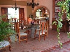 a dining room table with chairs and a chandelier hanging from it's ceiling