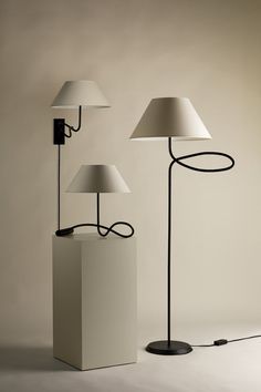 two lamps are sitting next to each other on the floor, one is plugged in