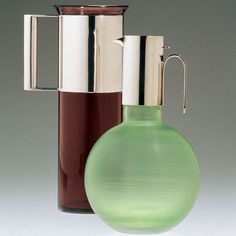 a green glass vase next to a brown one