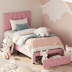 a bedroom with pink bedding and white accessories on the floor, along with toys