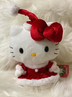 a hello kitty stuffed animal with a red bow on it's head and dress