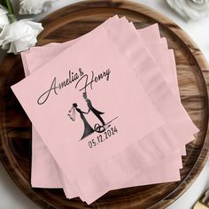 three pink napkins with the names of two people holding hands on top of each other