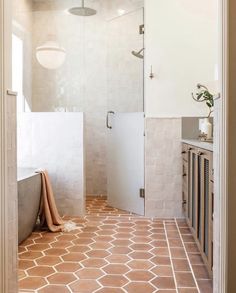 a bathroom with white walls and brown flooring