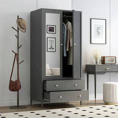 a grey armoire sitting next to a white wall and a black table with a brown bag on it