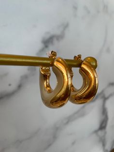 ✨Meet Leilani—where classic elegance meets modern allure. These gold-plated beauties are crafted with a chic, open-hoop design, radiating a lustrous shine that catches the light from every angle. ✨Their sleek, curved form is both bold and sophisticated, making them the perfect accessory for the woman who loves to command attention with understated luxury. ✨Ideal for both day and night, Leilani elevate any look with effortless grace. Whether paired with a power suit or a glamorous evening dress, they add a touch of timeless elegance and sensuality. ✨Let the Leilani Earrings be your go-to for a refined, yet daring, statement. Classic Gold-plated Jewelry With Gold Clasp, Chic Gold Earrings For Formal Occasions, Elegant Crescent Hoop Earrings For Everyday, Elegant Polished Metal Hoop Earrings, Everyday Gold Hoop Earrings With Plating, Gold Jewelry With Shiny Finish For Wedding, Minimalist Gold-plated Hoop Earrings, Elegant Teardrop Hoop Earrings With Polished Finish, Everyday Elegance 14k Gold Jewelry