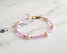 This gorgeous and dainty bracelet is made from high quality natural pink sapphires and 7 baby pink AAA grade freshwater pearls with all gold filled components that is tarnish resistant and suitable for everyday wear.  The length is 6.5 inches with 1 inch extension chain. Please message me if you need a customized size or without the extension chain, I need to confirm availability first as my supplies are very limited. Please note that while I try my best to capture the true colors of the bracele Elegant Pink Hypoallergenic Beaded Bracelets, Delicate Pink Round Bracelets, Elegant Pink Hypoallergenic Bracelet, Pink Dainty Pearl Bracelet, Delicate Pink Pearl Bracelet With Round Beads, Delicate Pink Pearl Bracelet As A Gift, Dainty Pink Pearl Bracelets, Delicate Pink Pearl Bracelet As Gift, Delicate Pink Pearl Bracelet Gift