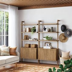 a living room filled with furniture and lots of greenery on top of the shelves