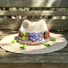 Check out our Handmade Straw Hat, your next go-to accessory for all things summer! This beauty is handcrafted with care in Mexico and made from breezy straw material, offering you the perfect combo of comfort and cool when the heat is on. Not to be missed, the hat features an eye-catching Peruvian embroidered band that adds a pop of color and wraps elegantly around the wide brim, giving it that extra flair. The floral embroidery on the band brings a lively bohemian vibe to the hat, making it a g Artisan Beach Hats One Size, Artisan Beach Hat, Embroidered Straw Hat For Beach With Short Brim, Beach Sun Hat With Embroidered Short Brim, Embroidered Short Brim Beach Hat, Bohemian Embroidered Sun Hat For Spring, Summer Embroidered Hat With Curved Brim, Spring Bohemian Embroidered Sun Hat, Beaded Multicolor Summer Hats