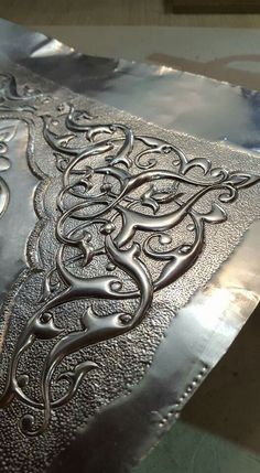 an intricately designed piece of metal is shown in the process of being cut and polished