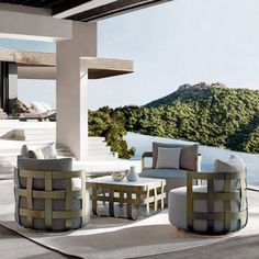 an outdoor living area with white furniture and large windows overlooking the water's edge