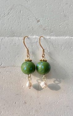 Handmade olive green and blue polymer clay bead dangle earrings with dyed cultured pearls and an 18k gold plated stainless steel fishhook style earring. Patterns on clay beads vary from piece to piece. Dangle Polymer Clay Single Earring, Dangle Single Earring Made Of Polymer Clay, Adjustable Jade Earrings With Ear Wire, Adjustable Jade Jewelry With Ear Wire, Gold Jewelry With French Hook And Round Beads, Adjustable Round Beads Jade Earrings, Jade Drop Earrings With Ear Wire, Green Pearl Drop Jewelry With Round Beads, Green 14k Gold Filled Earrings With Ear Wire