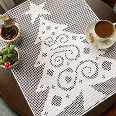 a table with two cups of coffee on top of it next to succulents