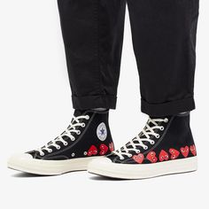 Since 2015, the creative synergy between Converse, an American shoe company with a century-old history, and Comme des Garçons PLAY, a daring offshoot of Japanese designer Rei Kawakubo's fashion house, has led to the reinvention of the classic Chuck Taylor 70. This iconic shoe is now adorned with Filip Pagowski's striking heart design. Originally debuted in 2009, this streetwear staple has successfully embraced contemporary trends while respecting its timeless silhouette. It's a testament to the unique blend of Converse's athletic heritage and Comme des Garçons PLAY's avant-garde aesthetics..Canvas Upper.Rubber Outsole Casual High-top Sneakers With Graphic Print For Sports, Casual High-top Sneakers With Logo Print For Streetwear, High-top Cotton Sneakers With Graphic Print, Casual High-top Sneakers With Graphic Print, Black Graphic Print High-top Sneakers For Streetwear, Black High-top Sneakers With Graphic Print For Streetwear, Chuck Taylor 70, Play Comme Des Garcons, Rei Kawakubo