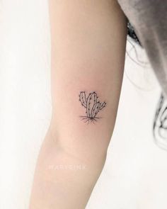 a small cactus tattoo on the arm