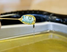 a person holding a toothpick with some liquid in it