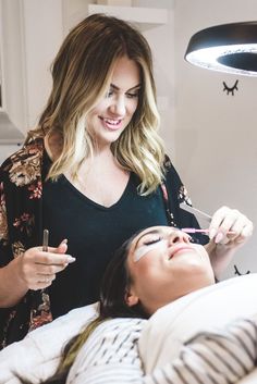 a woman getting her make up done by a professional makeup artist at the same time