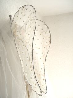 two white umbrellas are hanging on the wall with tulle skirt around them,