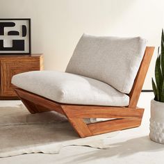 a wooden chair sitting on top of a white floor next to a dresser and lamp