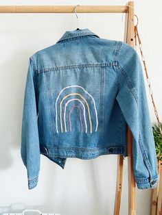 Thank you for your interest! This item is a hand embroidered denim jacket with a rainbow in different colors on the back. This jacket was thrifted from a local store.  -Denim jacket -Size XS -handmade -Refuge  - Thrifted  -Handwash or delicate bag Trendy Embroidered Cotton Denim Jacket, Casual Rainbow Cotton Outerwear, Casual Cotton Rainbow Outerwear, Trendy Rainbow Outerwear For Spring, Cotton Denim Jacket With Multicolor Embroidery And Pockets, Custom Embroidered Long Sleeve Denim Jacket, Hand Embroidered Denim, Embroidered Jean Jacket, Embroidered Denim Jacket