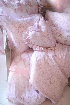 a bed with pink and white comforters on it