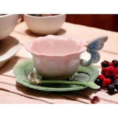 a cup and saucer on a plate with berries