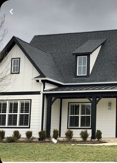 a white house with black roof and windows