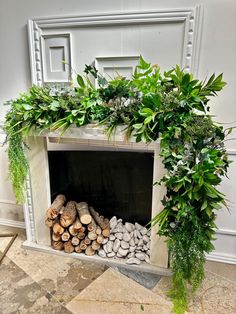 a fireplace decorated with greenery and rocks