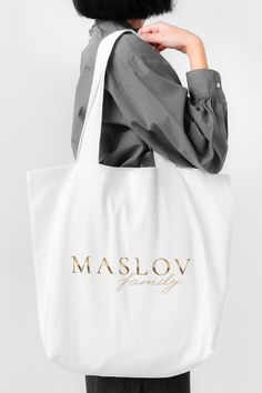 a woman holding a white bag with the word maslov on it