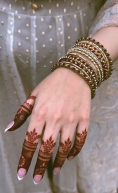 a woman's hands with hennap and bracelets