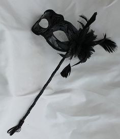 Stunning Black Masquerade Mask on a Stick with a flower made of black fabric petals, feathers and black and white organza $18.15  Handmade, Plastic, wood, paint with a tassel  Depth of Mask is 3”  Arrives 10-18 days later - Ships from the UK Black Masquerade Dress, Black Mask Masquerade, Masquerade Mask Aesthetic, Masquerade Aesthetic, Masquerade Mask Black, Silver Masquerade Mask, Black Masquerade, Couples Masquerade Masks, Fabric Petals