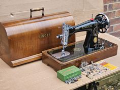 an old sewing machine sitting on top of a table next to a box and other items