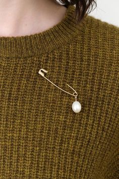 The Pearl Safety Pin Brooch is a stunning accessory that marries contemporary design with timeless beauty. This brooch showcases a lustrous freshwater pearl gracefully suspended from a large safety pin, offering a unique twist to your hairstyles or outfits. Perfect for those who appreciate a touch of sophistication, this brooch adds a radiant shimmer to any look. Safety Pin Accessories, Elegant Safety Pin Brooch, Wedding Brooch In Safety Pin Shape, Brooch Styling, Brooch Aesthetic, Safety Pins Fashion, Wedding Guest Outfit Fall, Large Safety Pin, Safety Pin Brooch