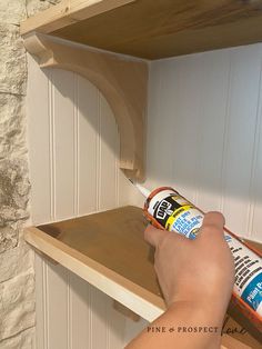 someone is painting the shelves in their kitchen