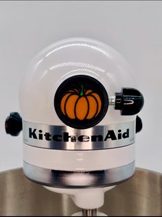 a kitchen aid blender sitting on top of a metal bowl with a pumpkin sticker on it