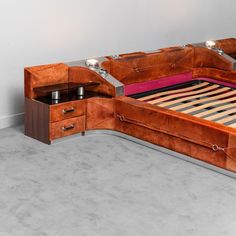 a bed that has drawers underneath it and is made out of wood with metal handles