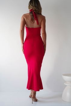 a woman in a red dress looking back