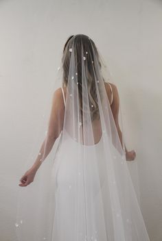 a woman in a white dress is wearing a veil