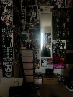 a room filled with lots of posters and pictures on the wall next to a dresser