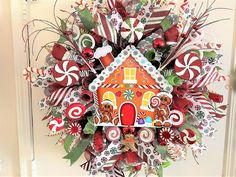 a christmas wreath with candy canes, candies and a gingerbread house on it