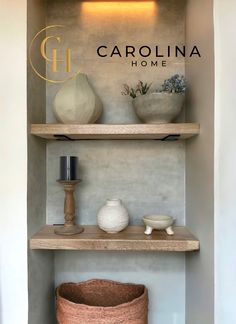 a shelf with some vases and other items on it in front of the carolina home logo