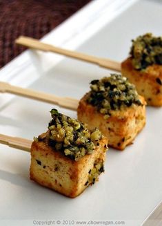 small appetizers with toppings sit on a white plate