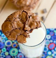 a cookie on top of a milkshake in a glass next to some cookies