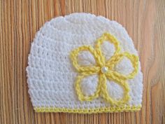 a crocheted hat with a yellow flower on the front and white brim