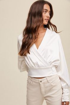 Wrap style satin blouse top.92% Polyester 8% SpandexRuns true to size. Model is wearing a small (34” bust, 26” waist, 35” hips, 5’6”) Bust Waist Length Sleeve Length Small 36 inches 28 inches 19 inches 25 inches Medium 38 inches 30 inches 20 inches 25 inches Large 40 inches 32 inches 21 inches 25 inches We measure each item from side seam to side seam, on a flat surface. Please consider the fabric content of each item, as fabric containing stretch may have give. V-neck Padded Blouse For Brunch, Feminine Satin Tops For Workwear, Feminine Satin Tops For Work, Padded V-neck Blouse For Brunch, Chic Stretch Satin Tops, Stretch Satin Tops For Date Night, Versatile Tops For Date Night In Spring, Versatile Fitted White Blouse, Versatile White Tops For Night Out