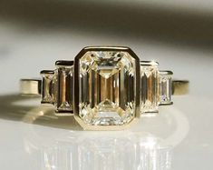 an emerald cut diamond ring with three baguets