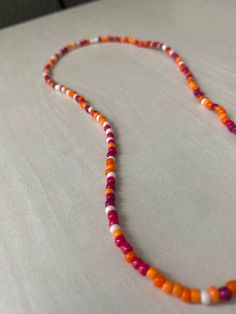 handmade beaded necklace in "sunset" 16-17 inches the necklace is elastic, and fits somewhat snug on most people (but it is not a choker) Adjustable Hand-strung Orange Necklaces, Adjustable Hand-strung Orange Necklace, Adjustable Orange Necklaces With Colorful Beads, Adjustable Orange Single Strand Beaded Necklace, Adjustable Orange Choker With Round Beads, Orange Single Strand Beaded Necklace With Round Beads, Orange Choker With Colorful Beads, Orange Single Strand Beaded Necklace, Bohemian Orange Single Strand Beads