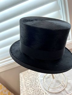 Antique turn of the century, silk plush top hat made by J Heinr JTA of Budapest. Hungary. It is a shiny silk plush. with a 1.25 black grosgrain ribbon. The sides are slightly curled but the front and back are more flat. It has a white silk lining with a cream leather sweatband that is discolored and not sewn in. Teh sweatband would need to be glued or restitched in, although it won't fall out 5 1/2 inches tall Brim - just under 1 15/16 at the front. Crown - 7 1/4'' x 6 1/4 Inside diameter - 22.2 Curved Brim Top Hat For Kentucky Derby Costume, Elegant Top Hat With Short Brim For Costume, Elegant Short Brim Top Hat For Costume, Elegant Costume Top Hat With Short Brim, Curved Brim Top Hat For Royal Ascot, Victorian Top Hat With High Crown For Formal Events, Victorian High Crown Top Hat For Formal Occasions, Formal Top Hat With Curved Brim For Royal Ascot, Victorian Top Hat With Short Brim For Formal Occasions